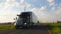 An Aurora truck on a rural road